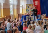 Grupa uczniów siedzi na korytarzu szkolnym