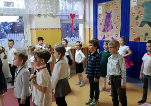 Grupa dzieci stoi i śpiewa piosenkę