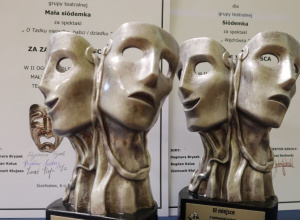 Statuetki na tle dyplomów
