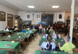 Uczniowie siedzą w ławkach starej klasy