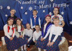 Uczniowie w strojach ludowych pozuja do zdjęcia