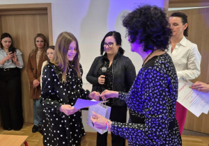 Uczennica odbiera nagrodę