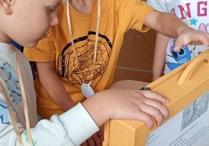 Uczniowie stoją przy stoliku
