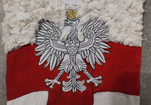 Godło Polski na tle biało- czerwonej flagi.