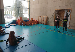 Czworo uczniów wykonuje ćwiczenia na hali sportowej.