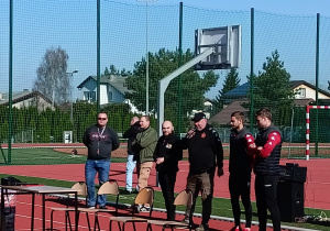 Piłkarze klubu RTS Widzew Łódź stoją na szkolnym boisku.