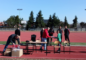 Piłkarz klubu RTS Widzew Łódź wręcza uczniowi nagrodę.