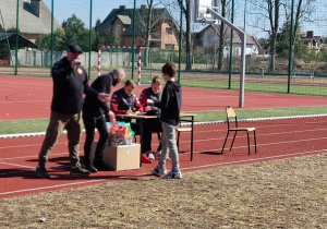 Piłkarz klubu RTS Widzew Łódź wręcza uczniowi nagrodę.