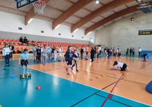 Uczniowie biorą udział w konkurencjach na hali sportowej.