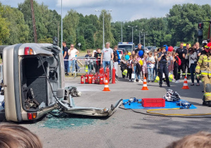 Pokaz straży pożarnej, która uczestniczy w wypadku drogowym- rozcinanie samochodu i wynoszenie rannych.