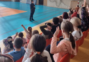 Uczniowie słuchają pogadanki policjantki