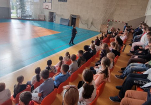 Uczniowie słuchają pogadanki policjantki