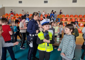 Uczeń w stroju policjanta stoi wśród dzieci