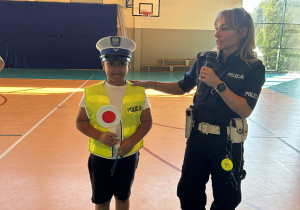 Pani sierżant tłumaczy jak wygląda strój Policjanta na służbie. Modelem jest chłopiec z klasy 5.