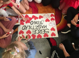 Uczniowie wykonują plakat z serc.