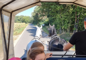 Uczniowie jadą wozem konnym.