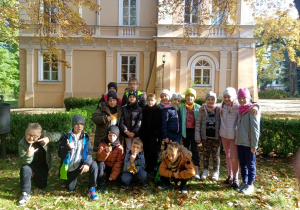 Grupa dzieci stoi przed budynkiem muzeum miejskiego.