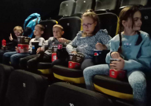 Uczniowie siedzą i czekają na seans filmowy