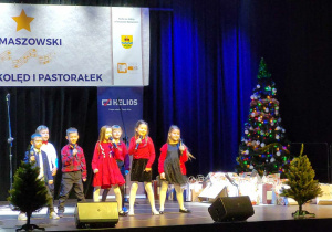 Grupa dzieci śpiewa na scenie