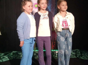Trzy uczennice pozują na scenie