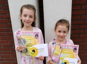 Dwie uczennice stoją i trzymają nagrody