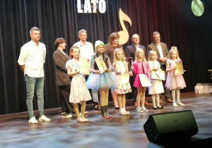 Zuzia wśród dzieci odbiera nagrodę na scenie