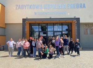 grupa dzieci pozuje przed wejściem do kopalni