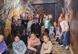 Uczniowie pozują przed zjazdem do sztolni kopalni