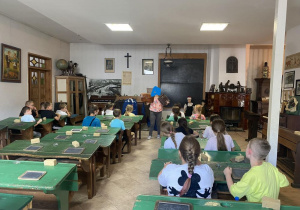 Uczniowie siedzą w ławkach starej klasy