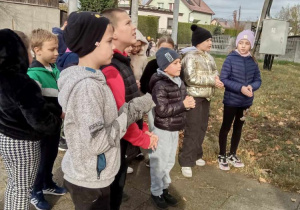 Grupa uczniów czyta informacje z tablicy
