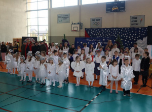 Liczna grupa uczniów pozuje na scenie