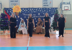 Cztery uczennice w czarnych strojach tańczą