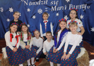 Uczniowie w strojach ludowych pozuja do zdjęcia