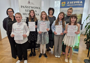 Sześcioro uczniów i trzech opiekunów pozuje do zdjęcia