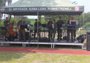Orkiestra wojskowa stoi na scenie