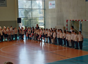 Uczniowie stoją na hali gimnastycznej