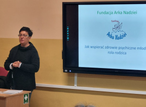 Osoba prowadząca warsztaty stoi przy tablicy