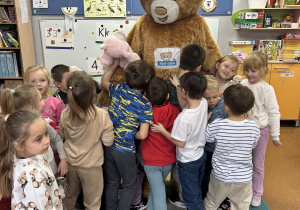 Dzieci stoją przy misiu