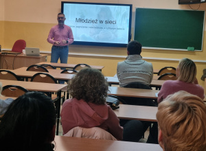 Rodzice słuchający wykładu w tle prowadzący