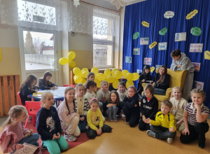 Grupa uczniów pozuje do zdjęcia ubrana w żółte kolory