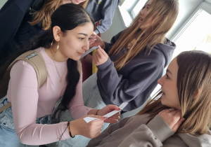 Uczennice przekazują sobie karteczki z zadaniami