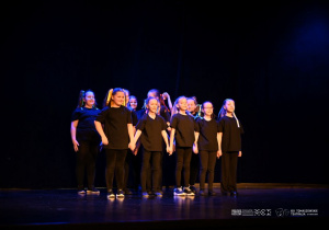 Dziewczynki w czarnych strojach stoją w zwartej grupie