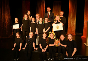 Zespłó teatralny Siódemka syoi na scenie i odbiera nagrodę