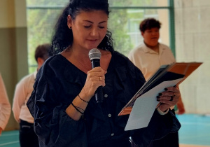 Pani wice dyrektor stoi z mikrofonem